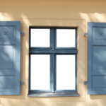 Un mur beige avec une fenêtre aux volets bleus, partiellement ouverts, projetant des ombres, il est peut-être temps de repeindre les volets.